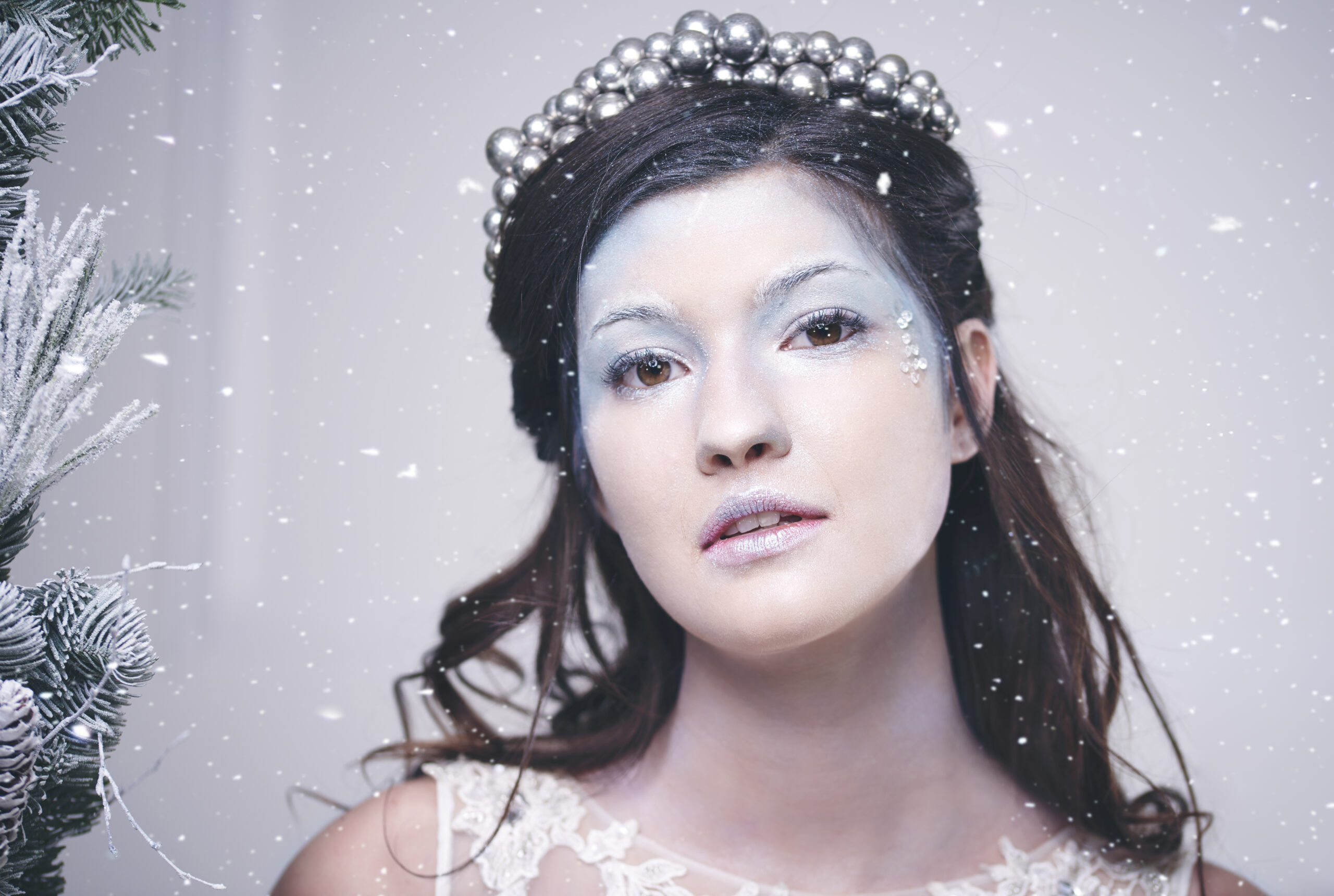 Portrait of beautiful snow queen among falling snow